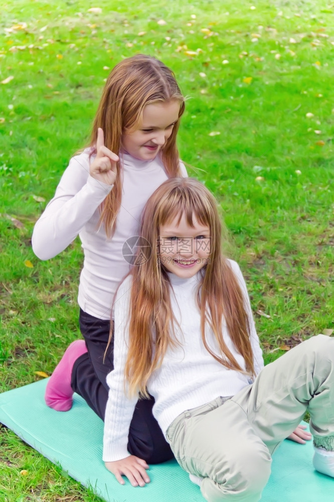 两个可爱的金发小女孩在户外玩耍图片