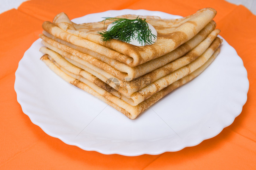 一堆俄罗斯煎饼在白色盘子上美味的食物奶油图片