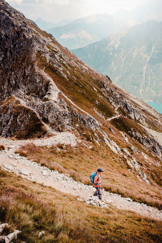 徒步旅行者独自的年轻人徒步在山上一条岩石小路远足图片