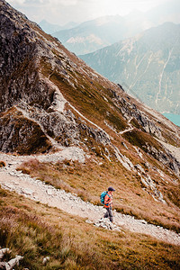 徒步旅行者独自的年轻人徒步在山上一条岩石小路远足图片