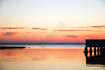 日出海岸以地平线和水反射为视野的色彩多日落金子图片