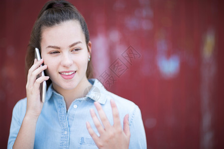 移动的连接城市环境中在移动电话上与外边交谈的少女人数孩图片