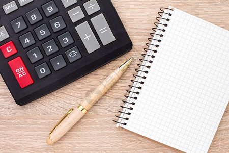 软垫财政金融的木制桌上笔记本圆球和计算器图片
