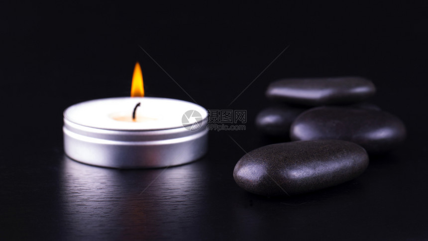 辉光黑宝石和背景蜡烛的近缝温暖泉图片