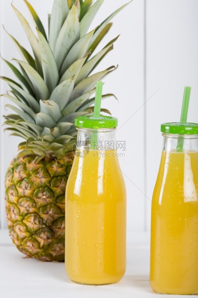 寒冷的菠萝汁装在玻璃瓶中有稻草果汁多的图片