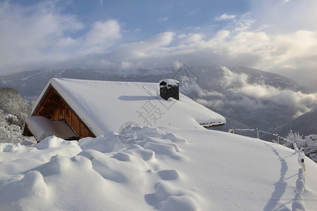 屋顶景观风优美高山村庄的木制小屋覆盖着山地新雪图片