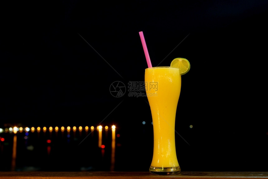 水果饮食黑底玻璃杯中橙色摇晃饮料图片