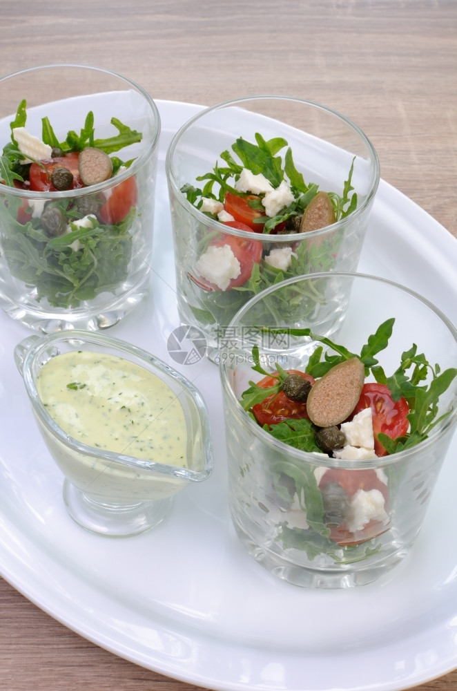 用樱桃西红柿披风和茶叶在玻璃杯中的沙拉盘子蔬菜有机的图片