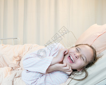 经过喜笑混合种族亚裔美国特ween女孩在医院床上患病的生图片