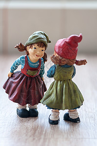 关闭木制桌上的两个花园小矮人Gnomes谈话树精女帽子图片