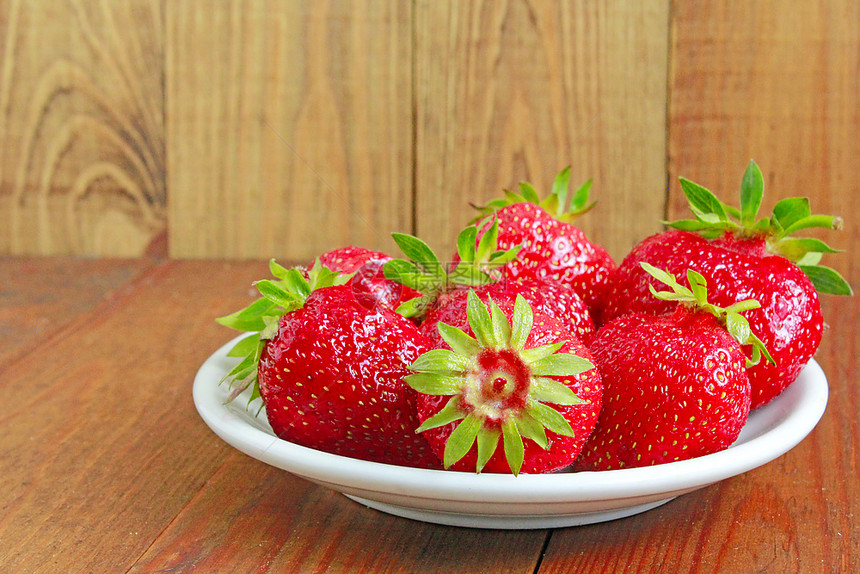 红色的成熟草莓在盘子上成熟的红草莓在棕色背景的白盘上植物群质地图片