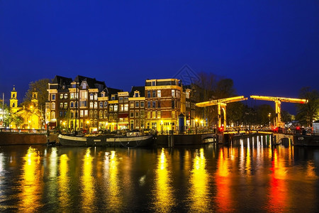 夜晚荷兰阿姆斯特丹与尔河的夜间城市景色晚上发光的图片