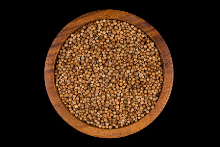 有机的木板黑底小碗中的Coriander种子图片