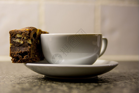 一杯新鲜的咖啡加一块巧克力蛋糕浅褐色的咖啡店餐具图片
