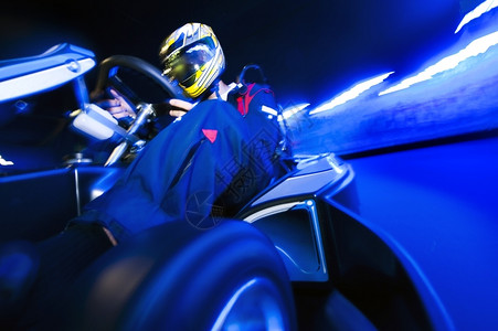 移位器GoCart赛车驾驶员在室内电路上登顶蓝色的黑暗图片