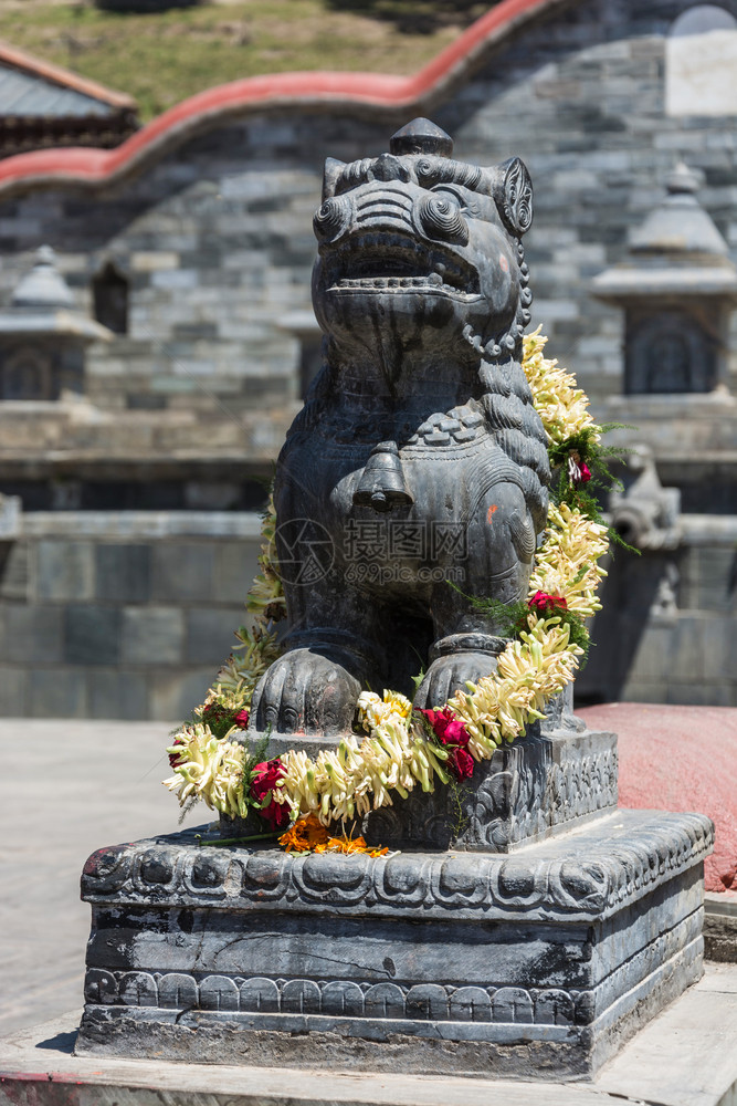宗教雕像结石在尼泊尔普什帕蒂那寺庙里佛教雕塑有一大朵花的圈图片