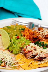 起司食用卡尼塔斯玉米饭墨西哥式餐porkCarnitas软卡尼塔斯甜食配有连煎豆西班牙大米盛满新鲜沙拉杂菜和辣瓜卡莫豆子图片