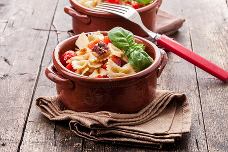 地中海意大利语餐巾木制桌上有樱桃番茄和橄榄的美味意大利面图片