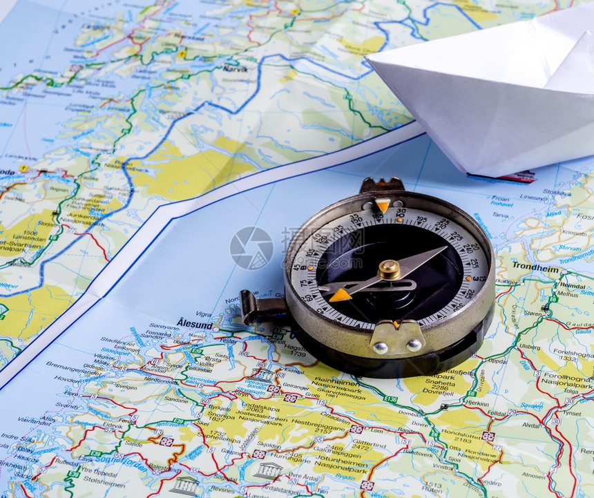 航程以罗盘和纸船的旅游者指南针和纸船的标旅行图片