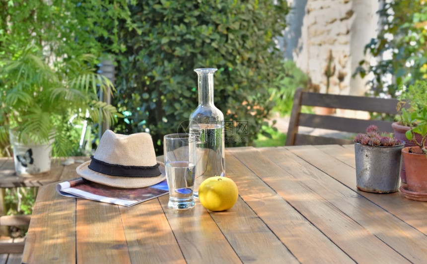 阳台椅子在乡间别墅花园的木桌上靠近水饮料和苹果在乡间别墅花园的木桌上靠近饮料和苹果木制的图片