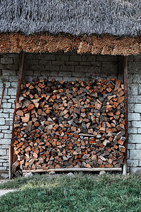 堆叠的一种桩在石头棚下储存的木柴在房子后院堆放木柴图片