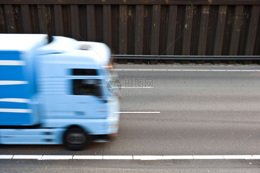 桩速度一条有线路和沥青的高速公路周围环绕着钢钉一辆蓝色卡车从左向右行驶到rkhgt线条图片