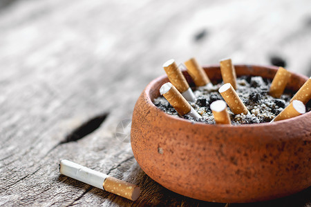 扔烟头锅里的烟头放在一个老木地板上即世界无烟草日概念筛选屁股背景