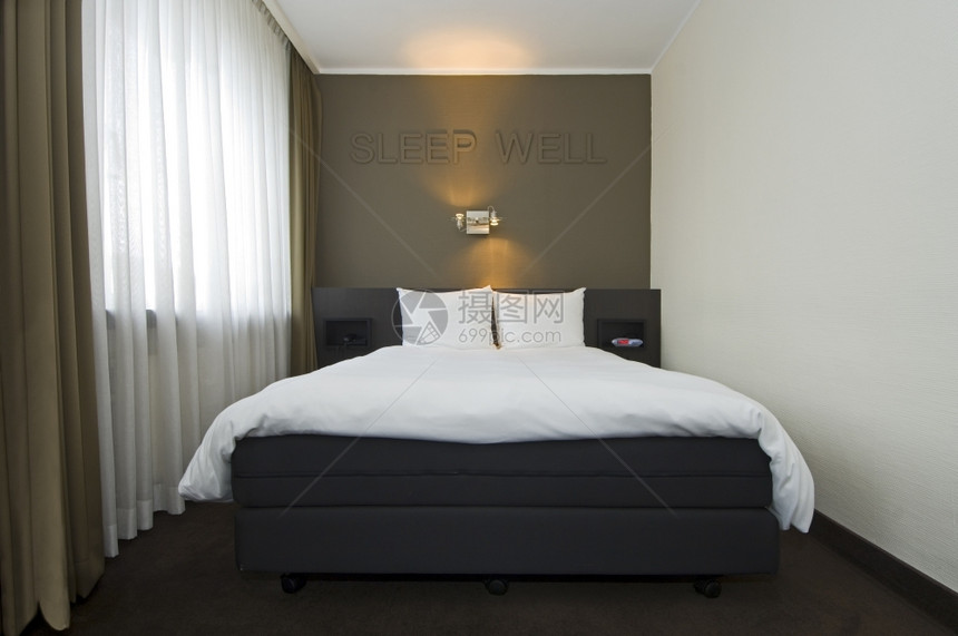 警报现代时尚的旅馆室内有双床拉窗帘夜光闹钟和文字睡井以缓解墙上的问题睡觉阅读图片