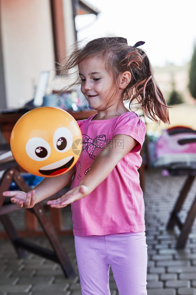人们可爱的小女孩在后院的家操场玩球快乐笑的孩子在夏日游乐馆玩得开心真实的人情况假期玩具图片