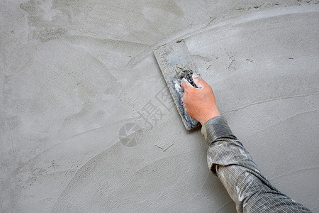 泥水匠成人具体的在建筑工地混凝土墙背景的水泥石膏上用粗金刚石打板的人手背景图片