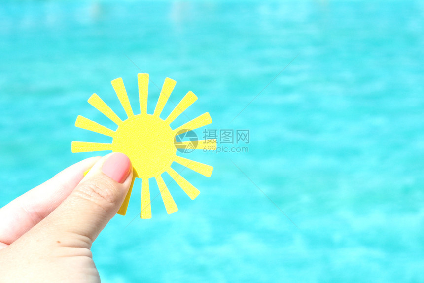 黄纸太阳在绿的池塘水背景下在雌手中夏天的概念海蓝色假期图片