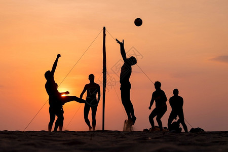 跳海滩排球运动员在海滩上和日落的操场沙子黑色人们图片