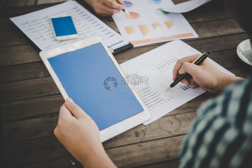 纸实业家使用平板片分析商业图营销报告在办公室工作实业家使用平板片分析商业图市场i利用平板片分析商业图市场i会计金融的图片