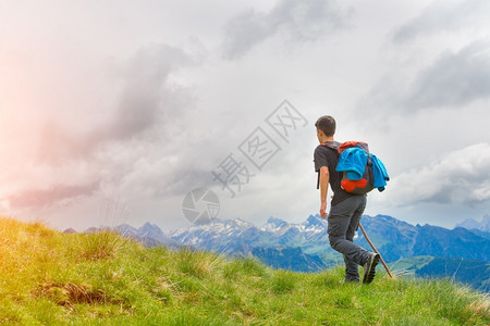 旅游娱乐男孩在山上走他的棍子在草地上的夏天快乐图片