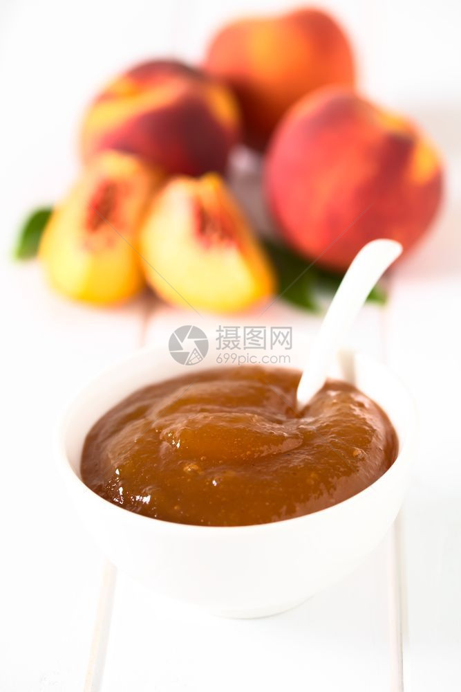 甜点以鲜熟的桃子果实在碗里拍摄白木上自然光选择焦点聚在中间果酱PeachJam或Jelly白色的食物图片
