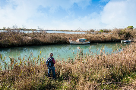 全程寻人海远足环礁湖的一条渔船停靠在环礁湖运河沿线的荒野地区大约60岁在荒地上寻人健康背景