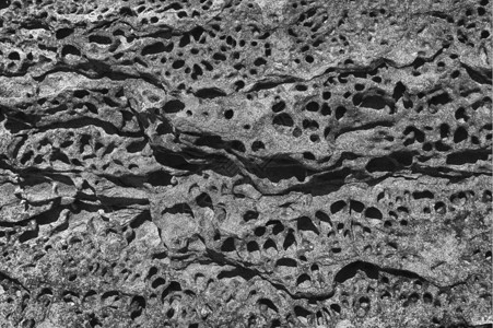 岛质地显示在哈蒙德角波纹岩石中盐水侵蚀所形成的洞穴自然摘要阴影图片