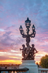 日落时在巴黎亚历山大三世桥的灯台蓬旅游行背景图片