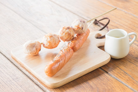 鱿鱼球和热狗烤在木板上盘子照片酱香料辣椒图片