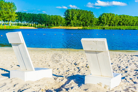 两张白色沙滩椅在海边图片
