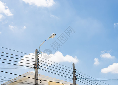蓝色的白邮政城市电线杆上的现代街灯泡图片