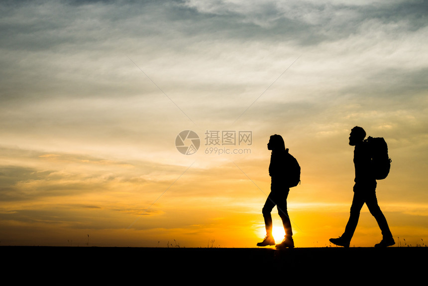 山两位徒步旅行者与背包享受日落时光的休眠轮回两位徒步旅行者与背包享受日落旅行概念天空男人图片