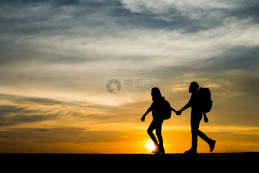 快乐的两位徒步旅行者与背包享受日落时光的休眠轮回两位徒步旅行者与背包享受日落旅行概念轮廓步图片