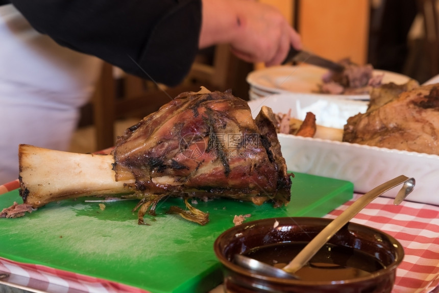 一顿饭腿在意大利餐厅切肉时烤牛的中点传统图片