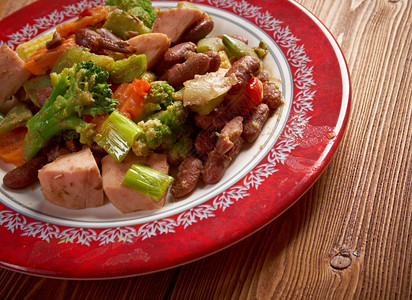 一顿饭午餐加猪肉香肠和锅里豆子的卡苏莱食物图片