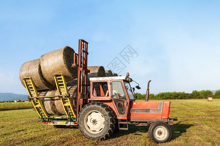 喂养拖拉机在巴罗农业地貌上抬起干草桶农场景观图片