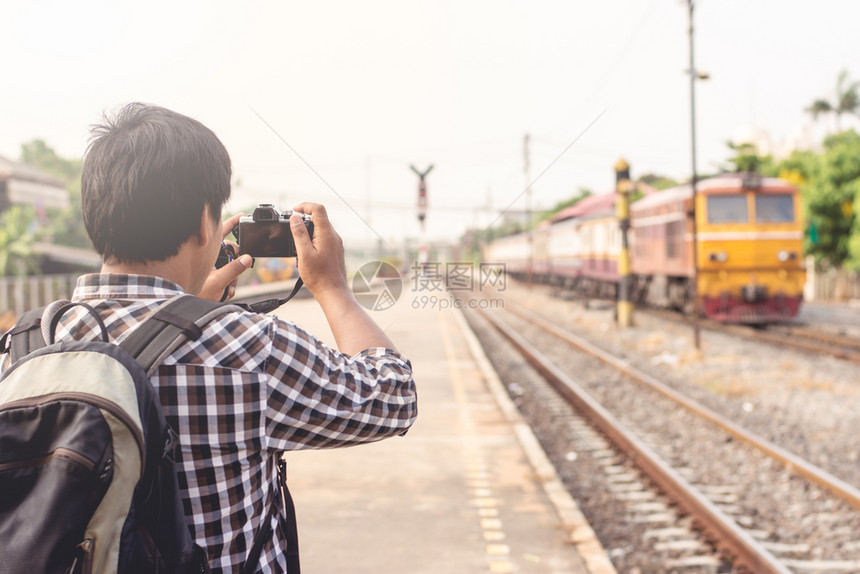 假期年轻观光青使用数码相机拍摄列车行驶的画面聪明摄影师图片