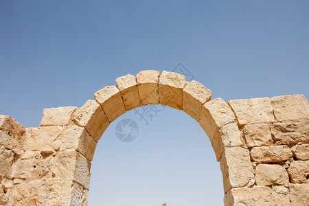 天空背景上的古石碑拱门废墟黄色拱道细节图片