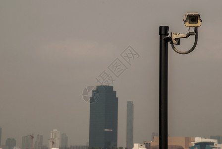 央视台标拥有城市背景墙上的现代监控摄像头已经发展的监视和目检查概念已开发的市景背墙上现代监控摄像机相发达设计图片