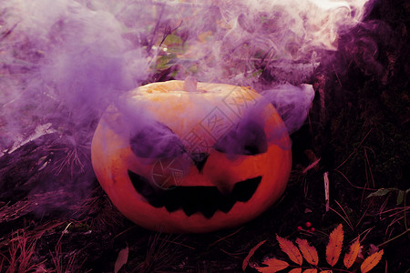 恐怖眼睛插座万圣节南瓜刻着可怕的口罩和紫色烟雾来自眼窝森林图片